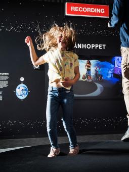 Två barn som hoppar månhoppet inne i Universeums utställning Rymdresan.