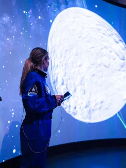 En guide kollar på en asteroid på en skärm.
