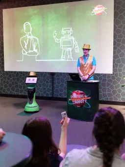 En robot och en programledare pratar inför en publik.